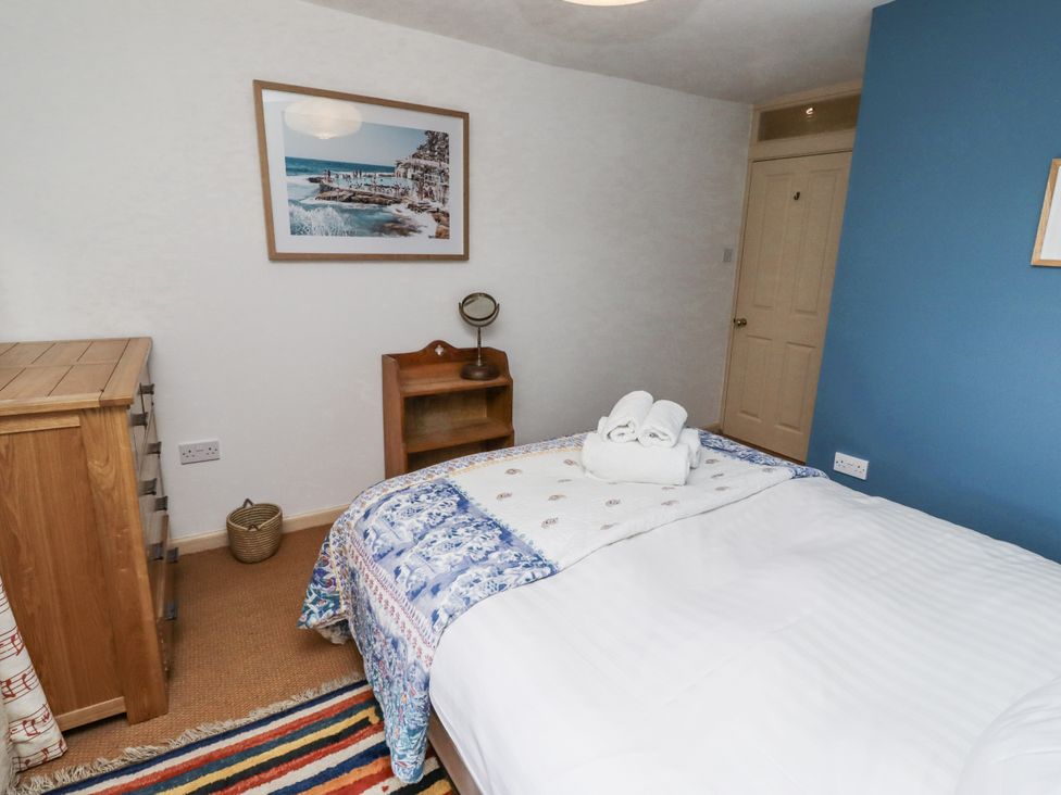 A bedroom with a bed and dresser at Elford Farmhouse Seahouses