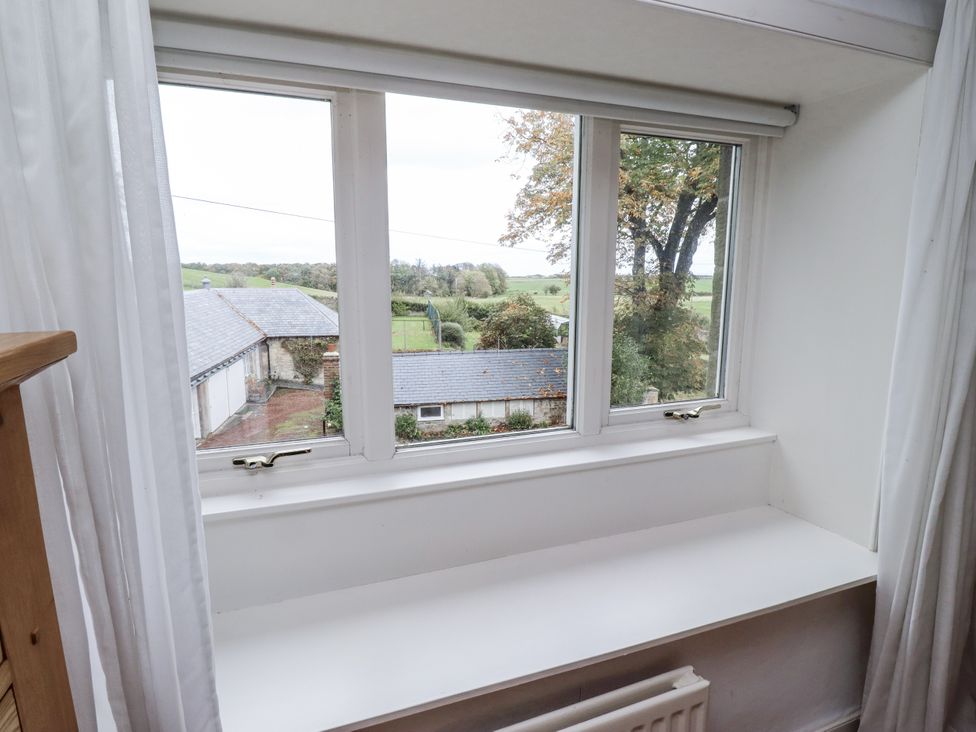 A window with a view of a field and buildings at Elford Farmhouse in Seahouses