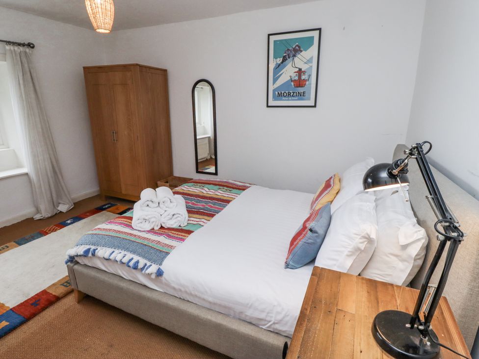 A bedroom with a bed and wardrobe at Elford Farmhouse in Seahouses