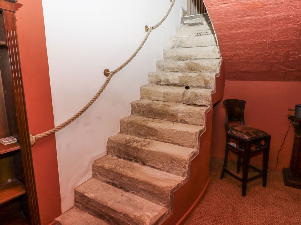 A staircase with stone steps and a handrail at Elford Farmhouse in Seahouses