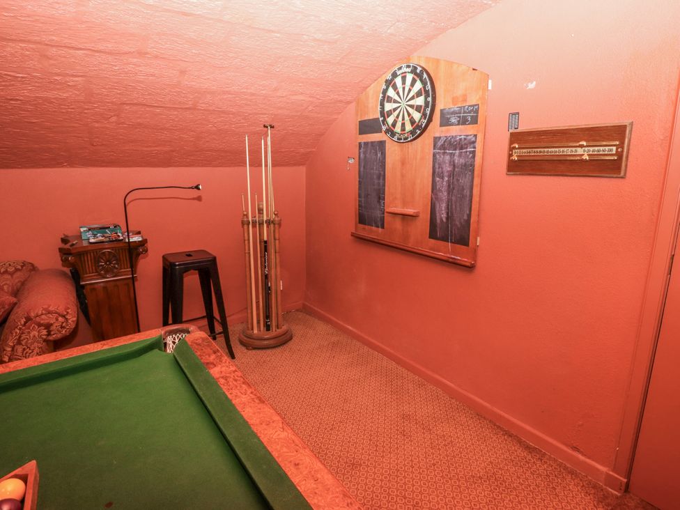 A game room with a pool table and dartboard at Elford Farmhouse in Seahouses
