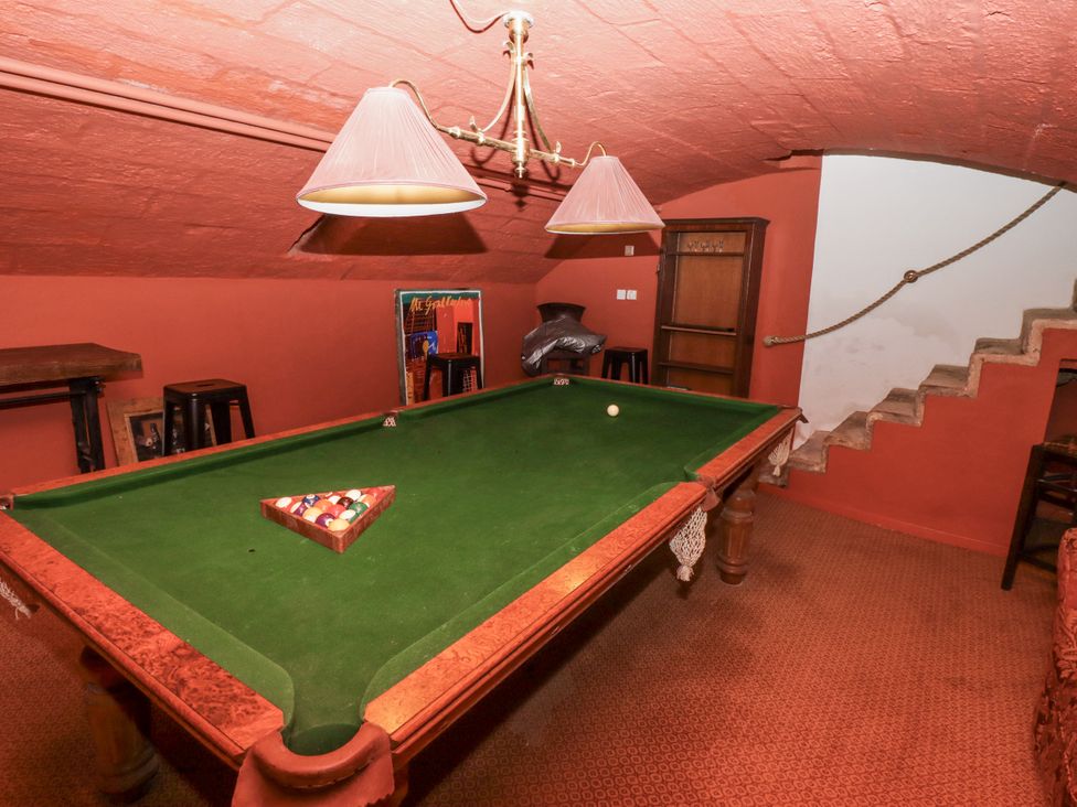 A game room with a pool table and bar stools at Elford Farmhouse in Seahouses