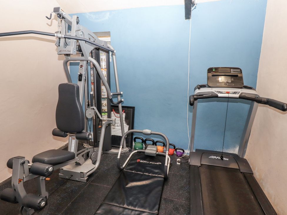 A gym with exercise equipment and a treadmill at Elford Farmhouse Seahouses