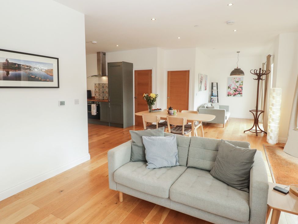 A living room with a sofa and dining table at The Lodge in Bridgend