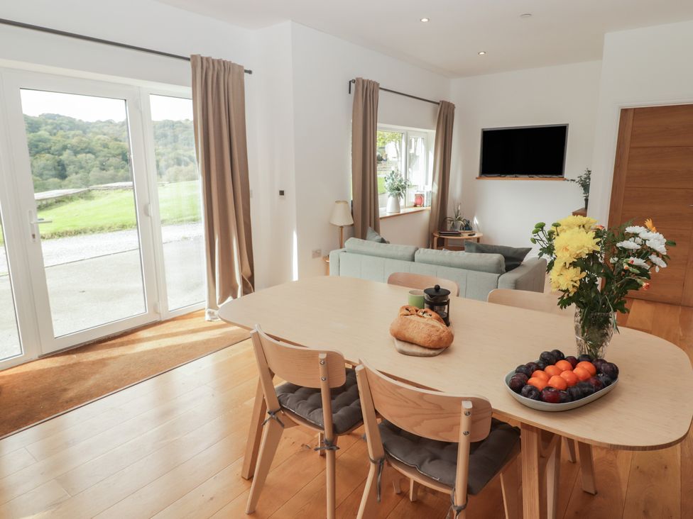 A dining room with a table and chairs at The Lodge in Bridgend