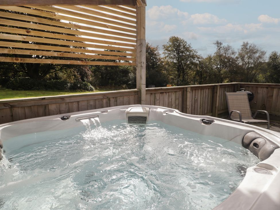 A hot tub on a deck at The Lodge in Bridgend