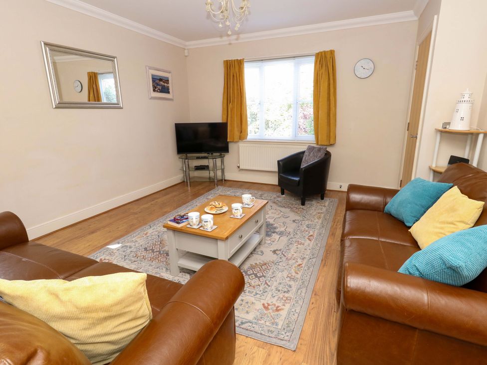 A living room with a television and coffee table at Farthings in Weymouth