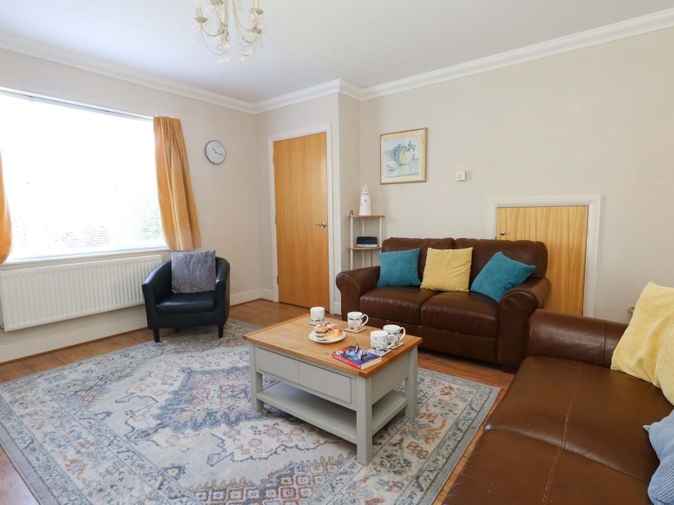 A living room with a sofa and coffee table at Farthings in Weymouth