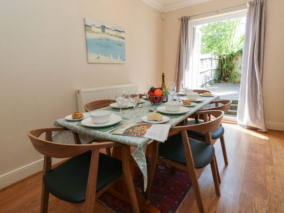 A dining room with a table set for meals at Farthings in Weymouth