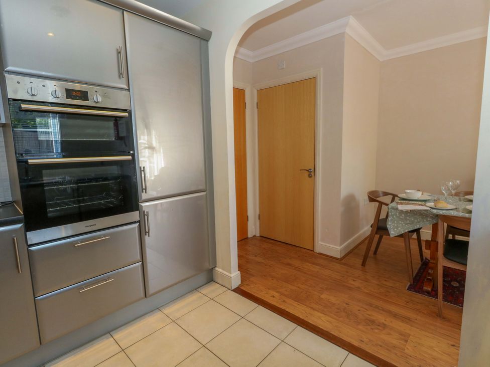 A kitchen with an oven and dining area at Farthings in Weymouth