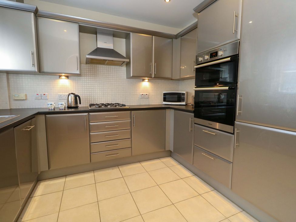 A kitchen with appliances and cabinetry at Farthings in Weymouth