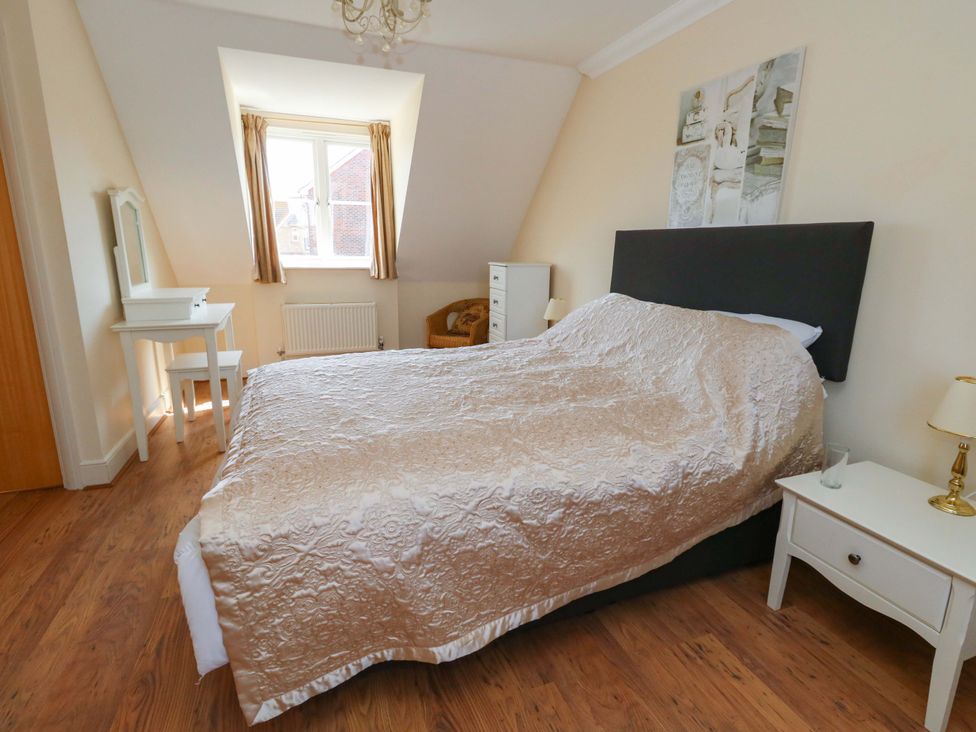 A bedroom with a bed and furniture at Farthings in Weymouth