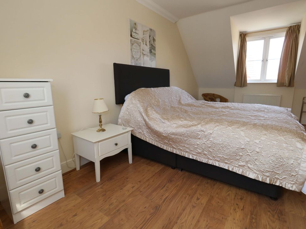 A bedroom with a bed and nightstand at Farthings in Weymouth