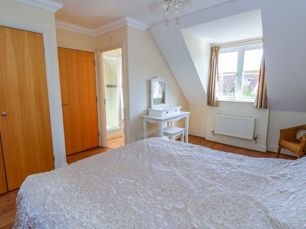 A bedroom with a bed and dresser at Farthings in Weymouth