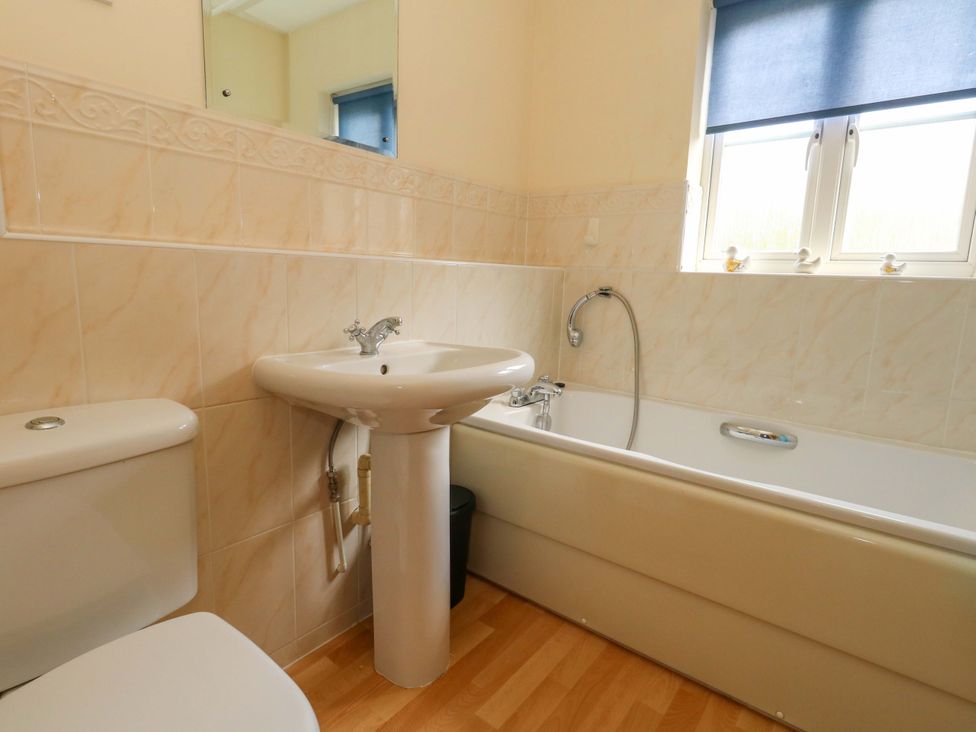 A bathroom with a toilet sink and bathtub at Farthings in Weymouth