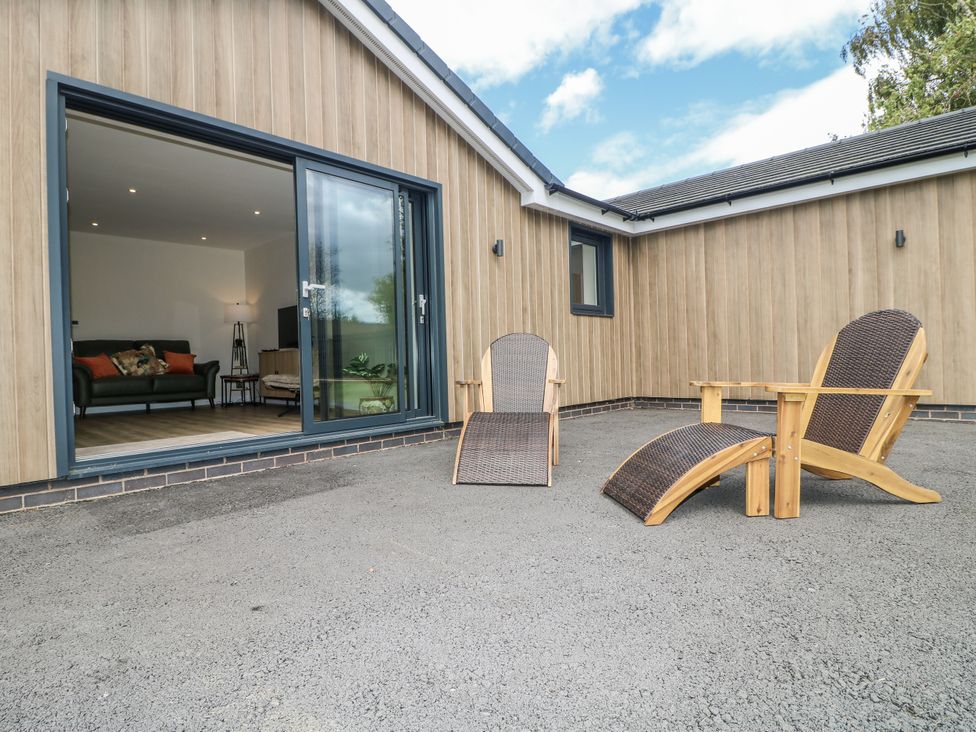 Two outdoor chairs in front of a sliding door at Fields View Edingale near Alrewas