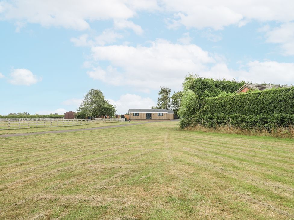 An outdoor view of a house and shed with grass at Fields View Edingale near Alrewas