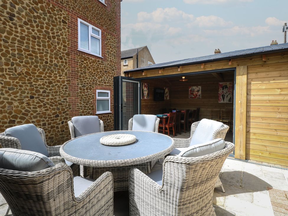 An outdoor garden with a table and chairs at The Burleigh in Hunstanton