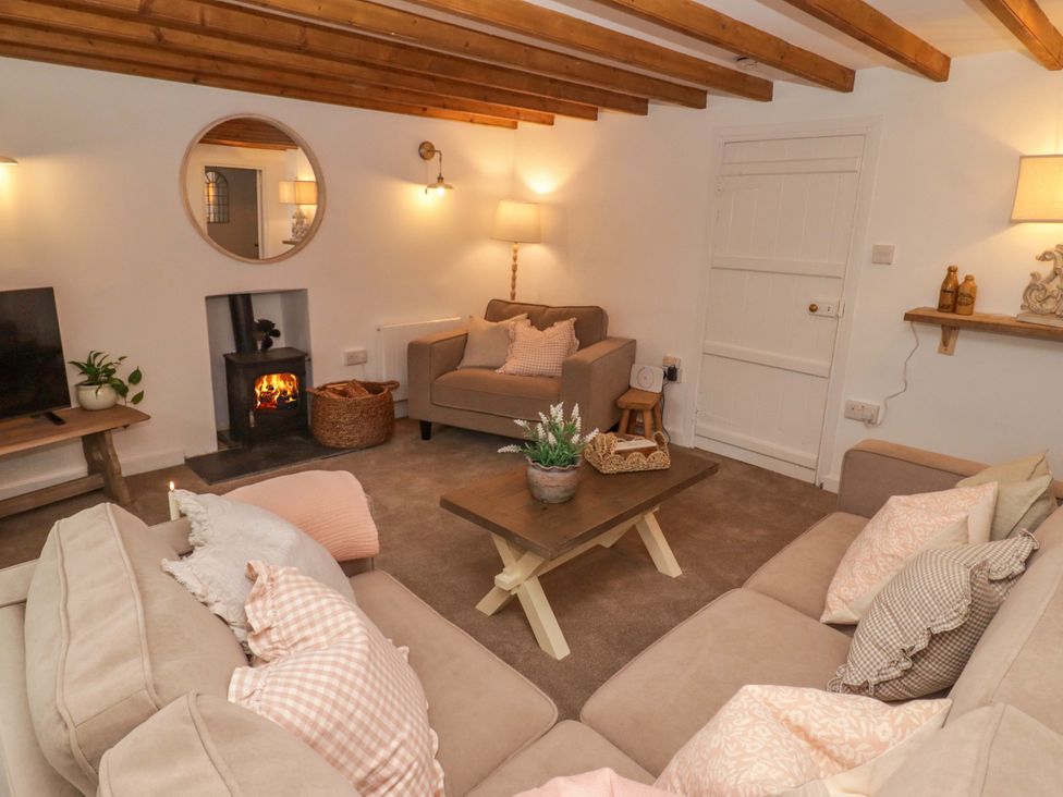 A living room with a sofa and fireplace at Penwyn in Solva