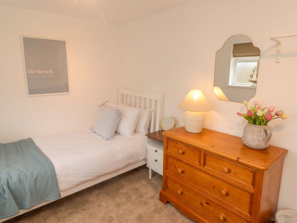 A bedroom with a single bed and wooden dresser at Penwyn in Solva