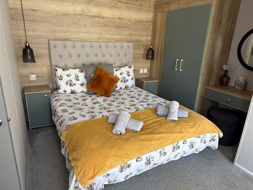 A bedroom with a bed and wardrobe at Seren in Broughton, Cumbria
