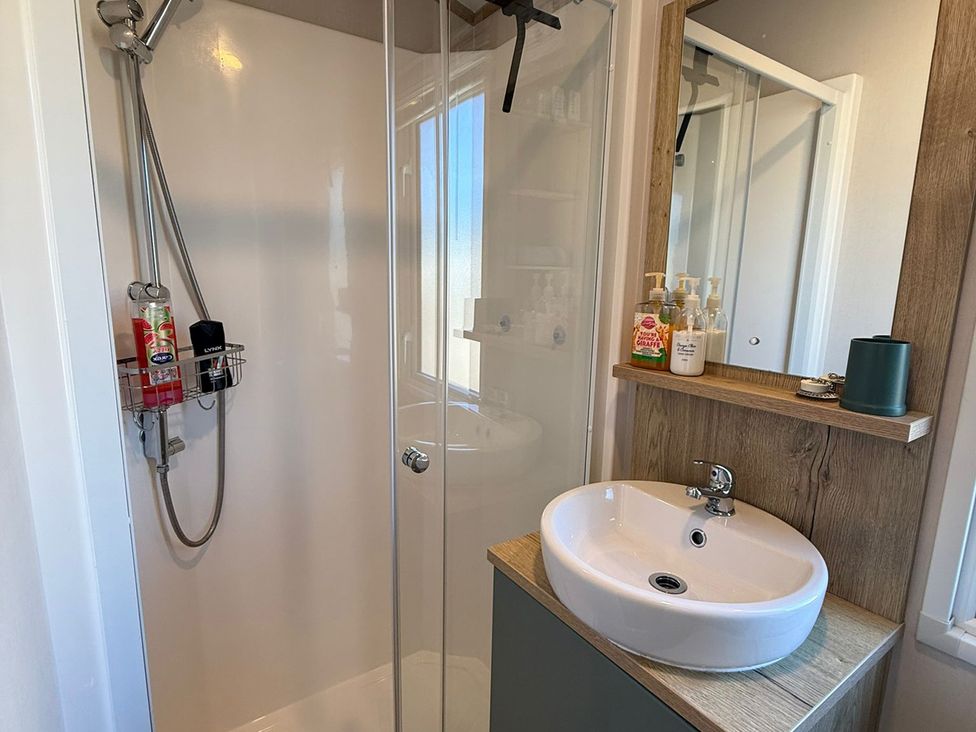 A bathroom with a shower and sink at Seren in Broughton, Cumbria
