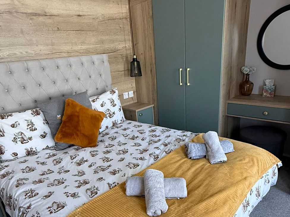 A bedroom with a bed and wardrobe at Seren in Broughton, Cumbria