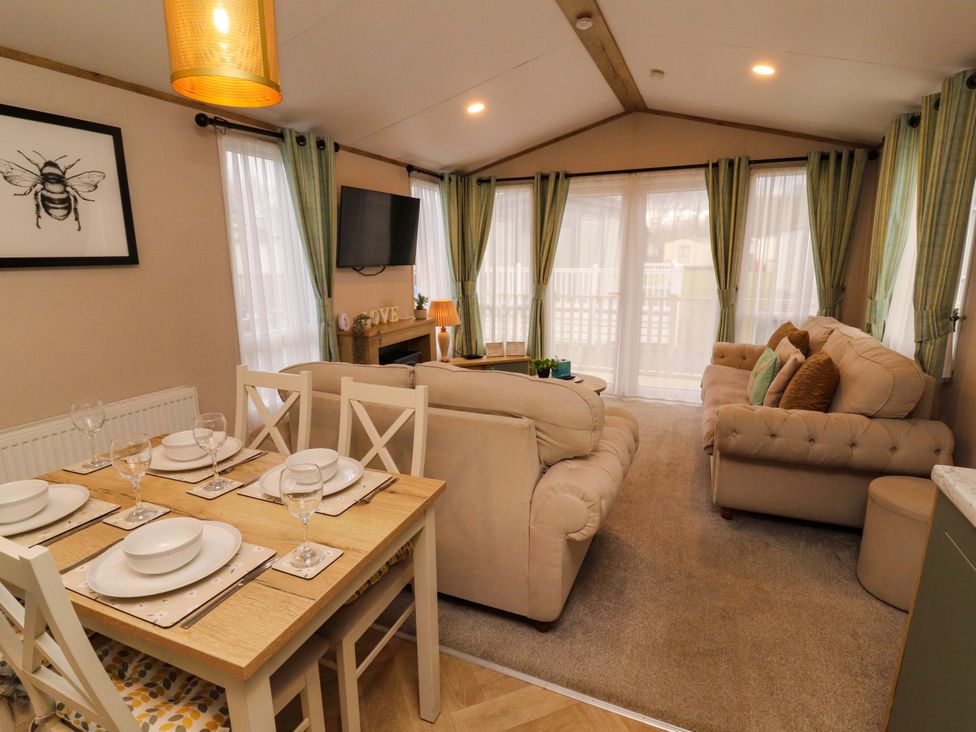 A living room with a dining area and television at Seren in Broughton, Cumbria
