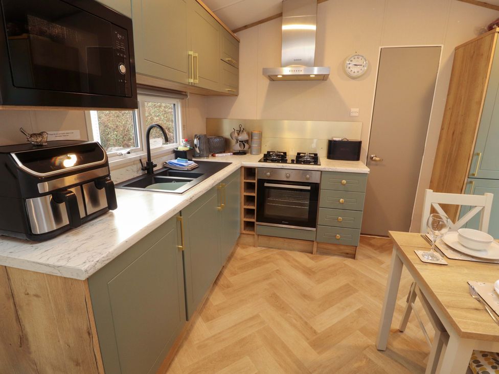 A kitchen with appliances and a dining table at Seren in Broughton, Cumbria