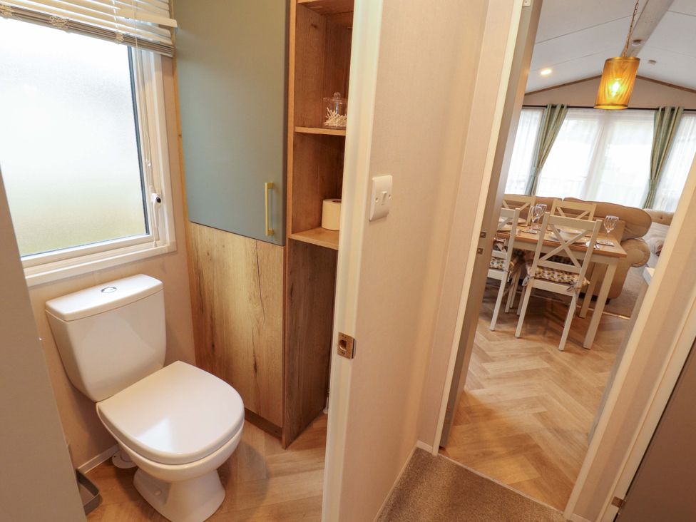 A bathroom with a toilet and shelf at Seren, Broughton, Cumbria