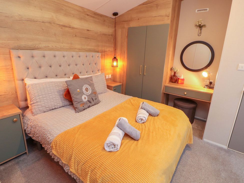A bedroom with a bed and wardrobe at Seren Broughton, Cumbria