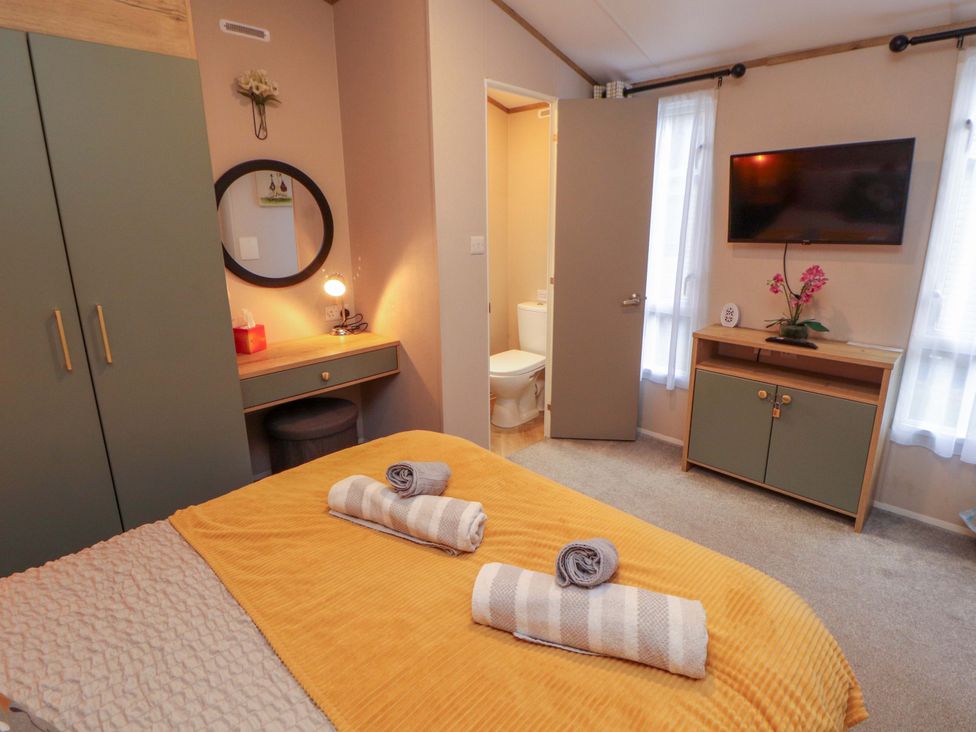 A bedroom with a bed and television at Seren in Broughton, Cumbria