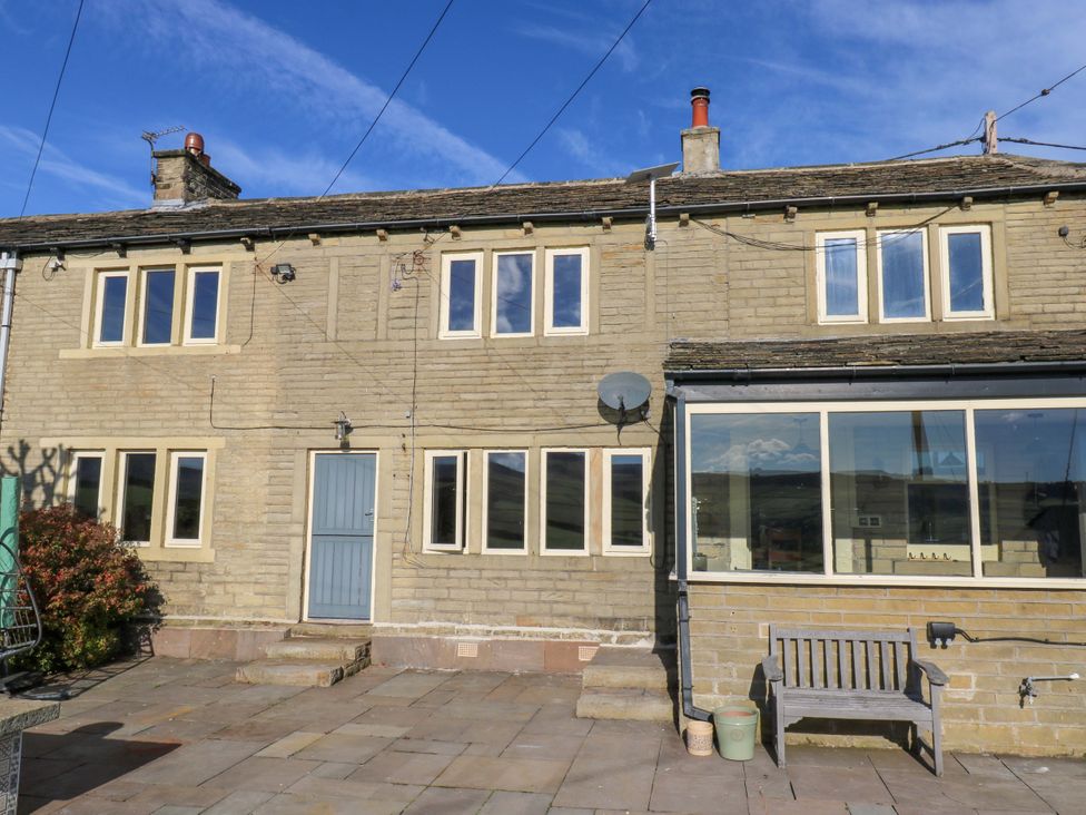 A house with a bench and windows at 1 Flush House Lane Holmbridge