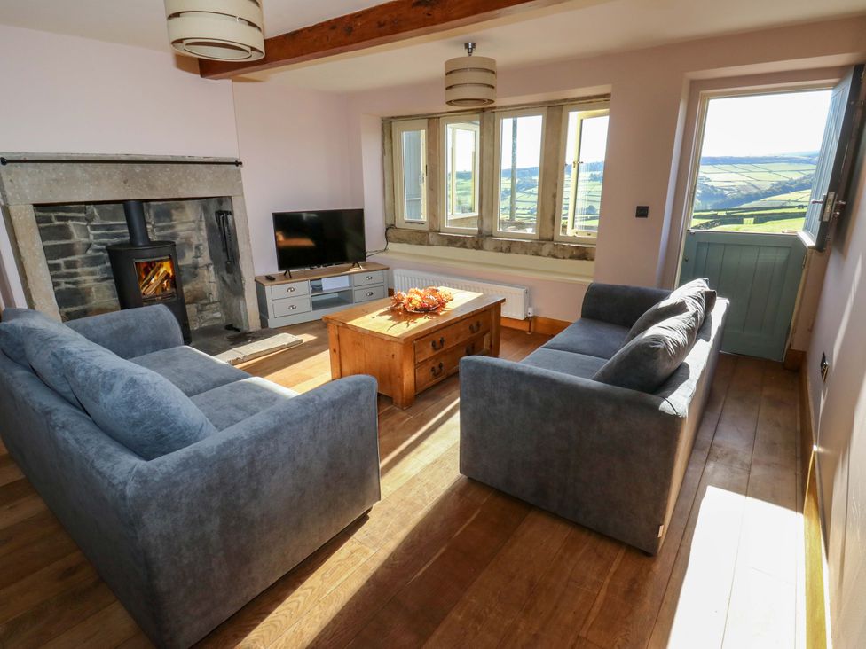 A living room with a sofa and television at 1 Flush House Lane, Holmbridge