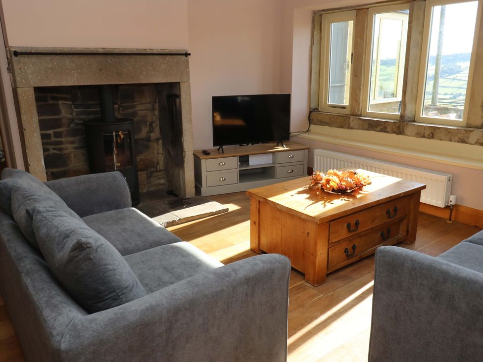 A living room with a fireplace and television at 1 Flush House Lane in Holmbridge