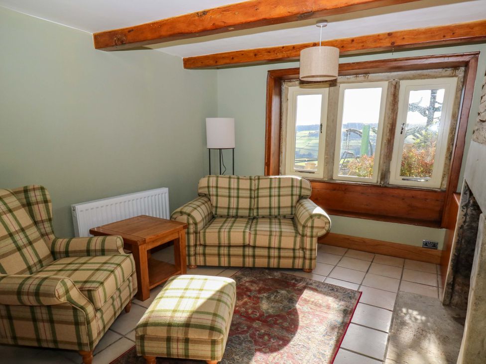 A living room with a chair and sofa at 1 Flush House Lane in Holmbridge
