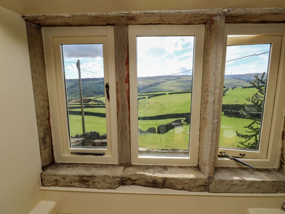 A view through windows showing green landscape at 1 Flush House Lane in Holmbridge