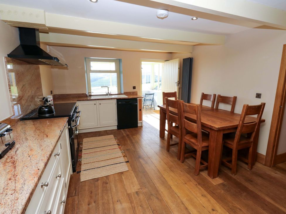 A kitchen with a dining table and cabinets at 1 Flush House Lane Holmbridge