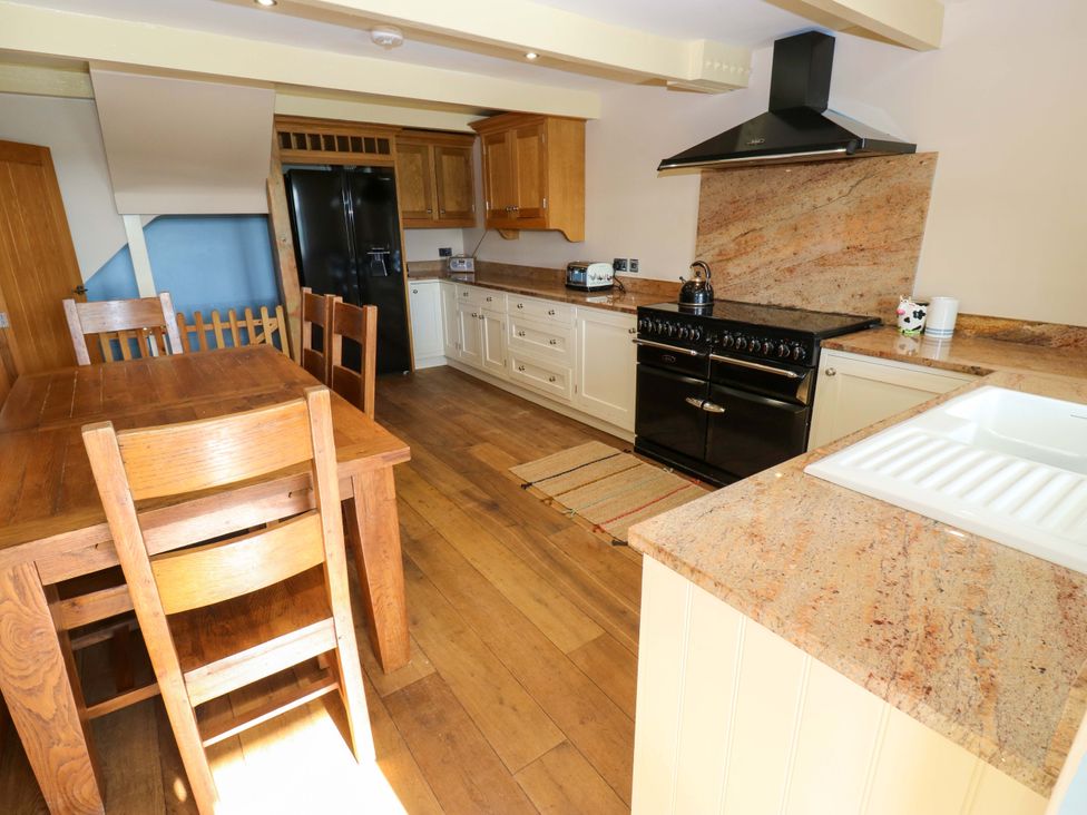 A kitchen with a table and chairs at 1 Flush House Lane Holmbridge