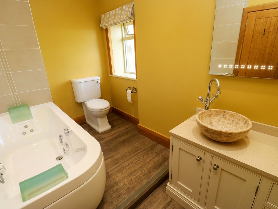 A bathroom with a tub, toilet, and sink at 1 Flush House Lane Holmbridge