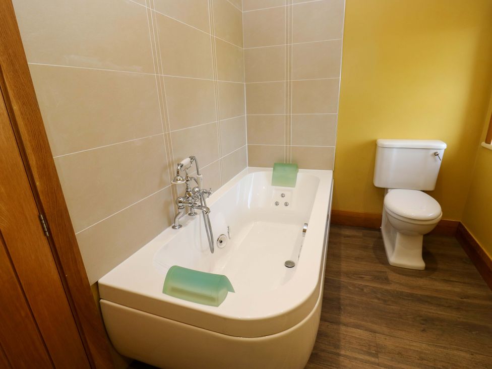 A bathroom with a bathtub and toilet at 1 Flush House Lane in Holmbridge