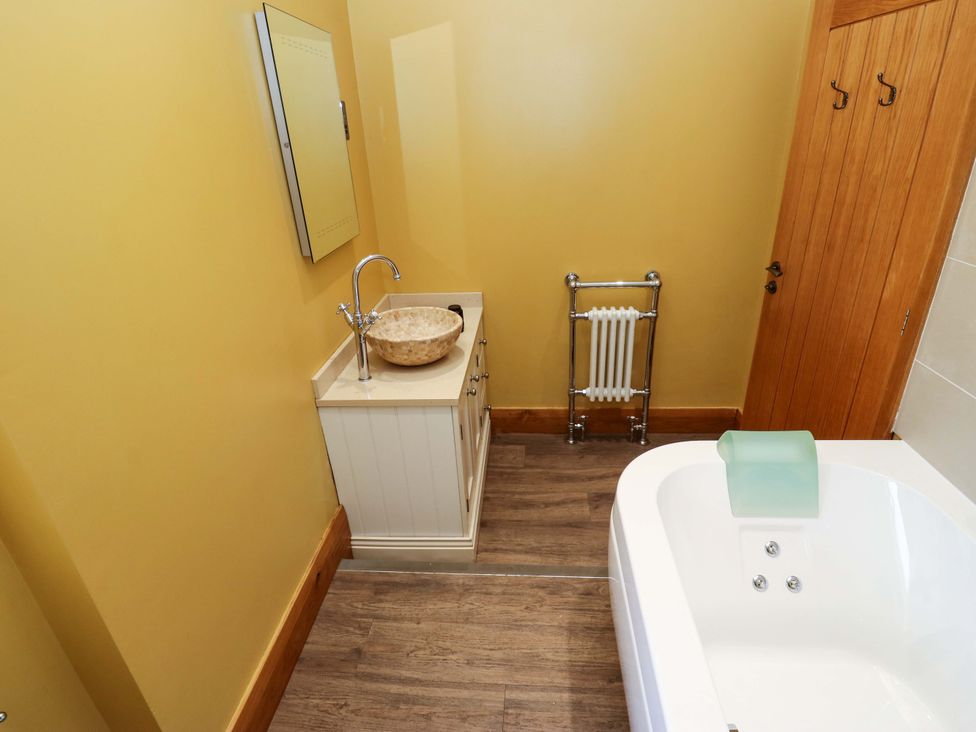 A bathroom with a sink and bathtub at 1 Flush House Lane Holmbridge