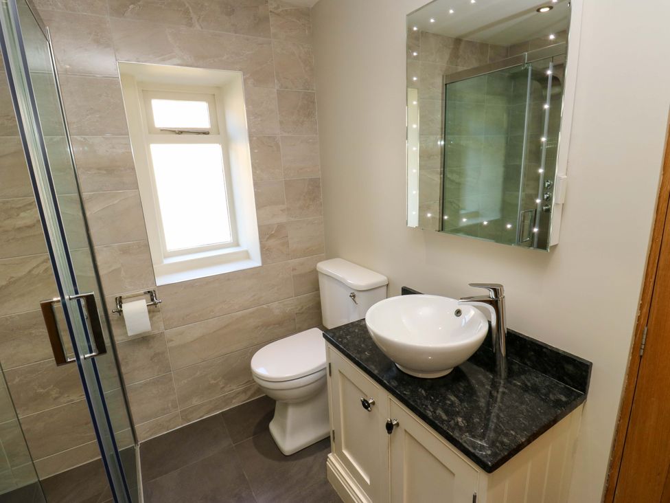 A bathroom with a shower, toilet, and sink at 1 Flush House Lane Holmbridge