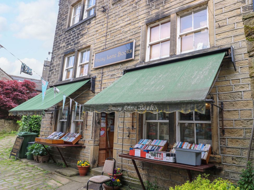 An outdoor bookshop with tables and books at Daisy Lane Books in Holmbridge