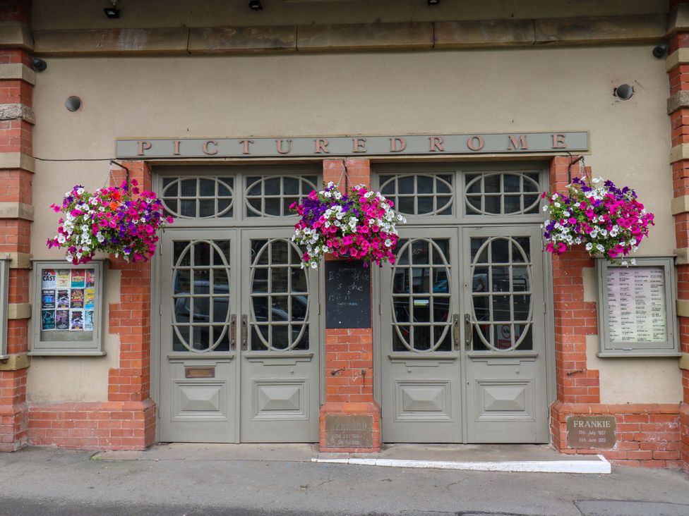 An entrance with double doors and hanging baskets at Picturedrome in Holmbridge