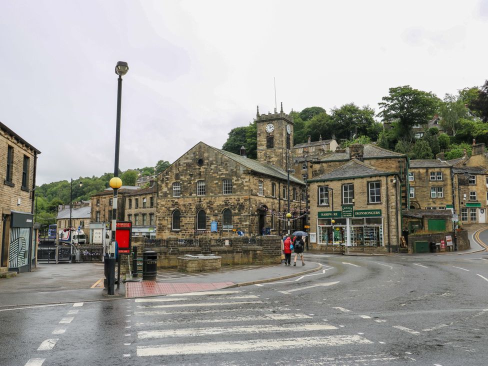 A street scene with a clock tower and buildings at 1 Flush House Lane in Holmbridge