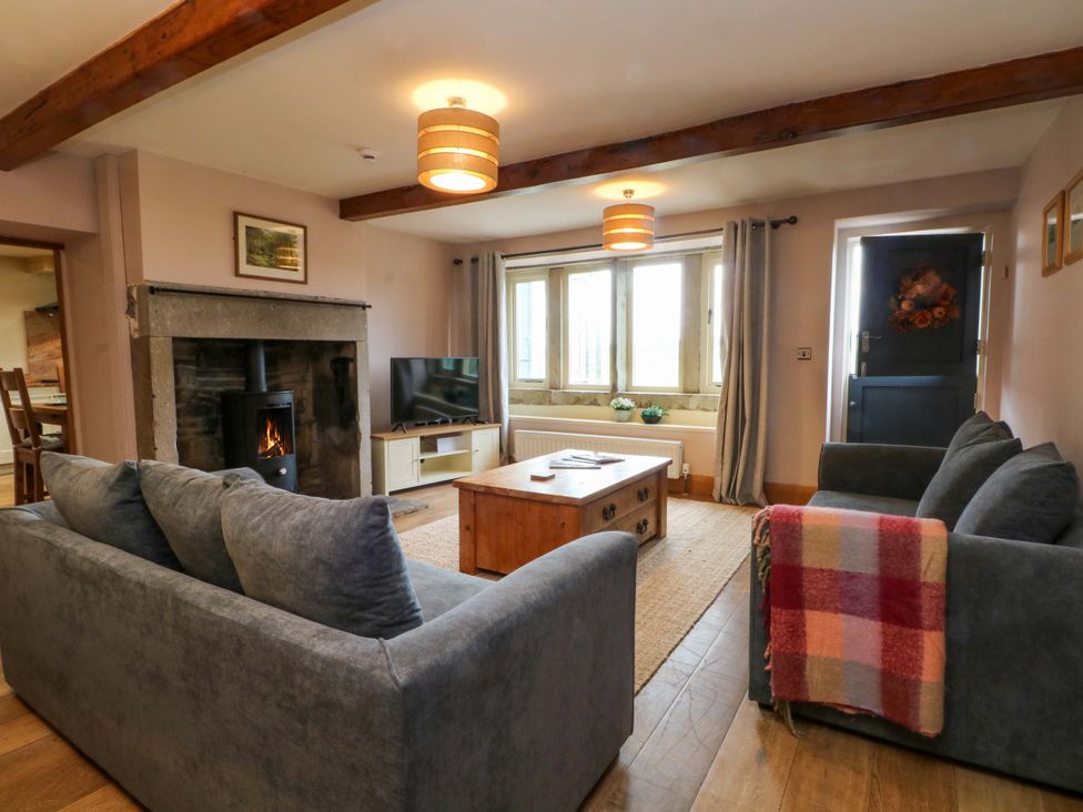 A living room with a sofa and coffee table at Stone & Fleece Cottage in Holmbridge