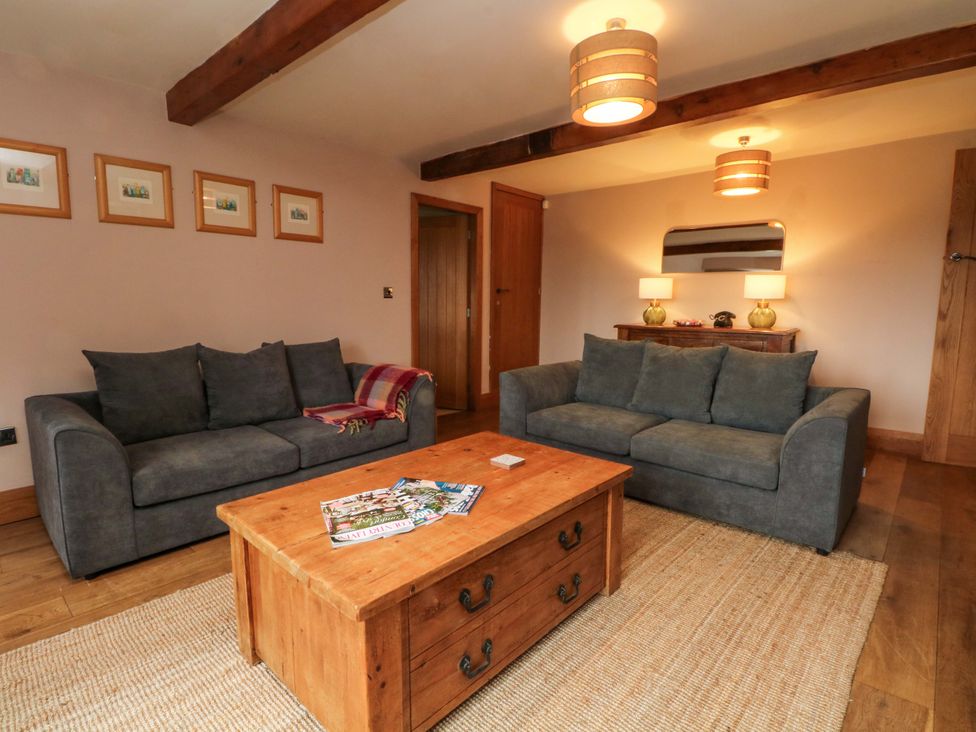 A living room with sofas and a coffee table at Stone & Fleece Cottage in Holmbridge