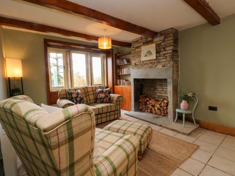 A living room with chairs and a fireplace at Stone & Fleece Cottage in Holmbridge