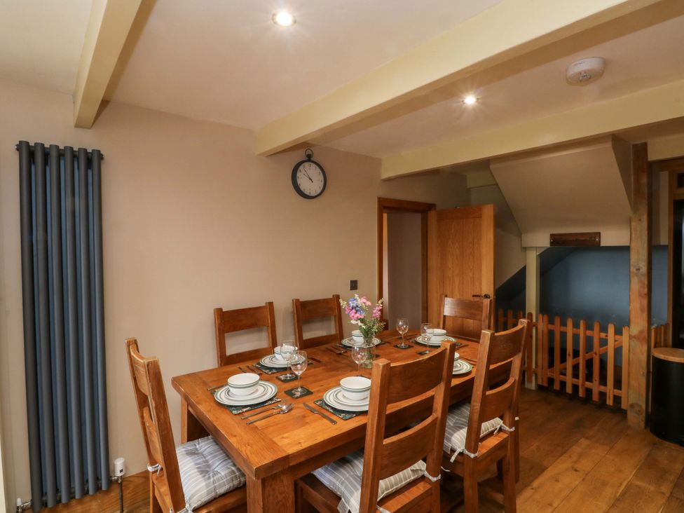 A dining area with a table and chairs at Stone & Fleece Cottage in Holmbridge